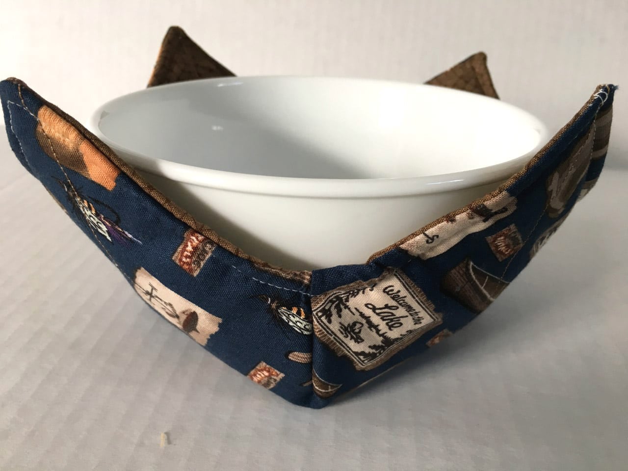https://madeinmichigan.com/wp-content/uploads/2019/11/At-The-Lake-Microwave-Bowl-Holder-Cozy.jpg