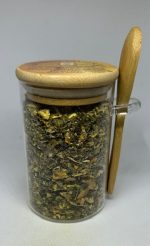 Organic Turmeric Ginger Tea in jar with wooden spoon